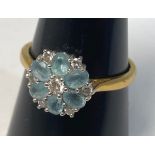An 18ct yellow gold aquamarine and diamond dress ring, in a daisy style setting, weighs 4.2 grams,
