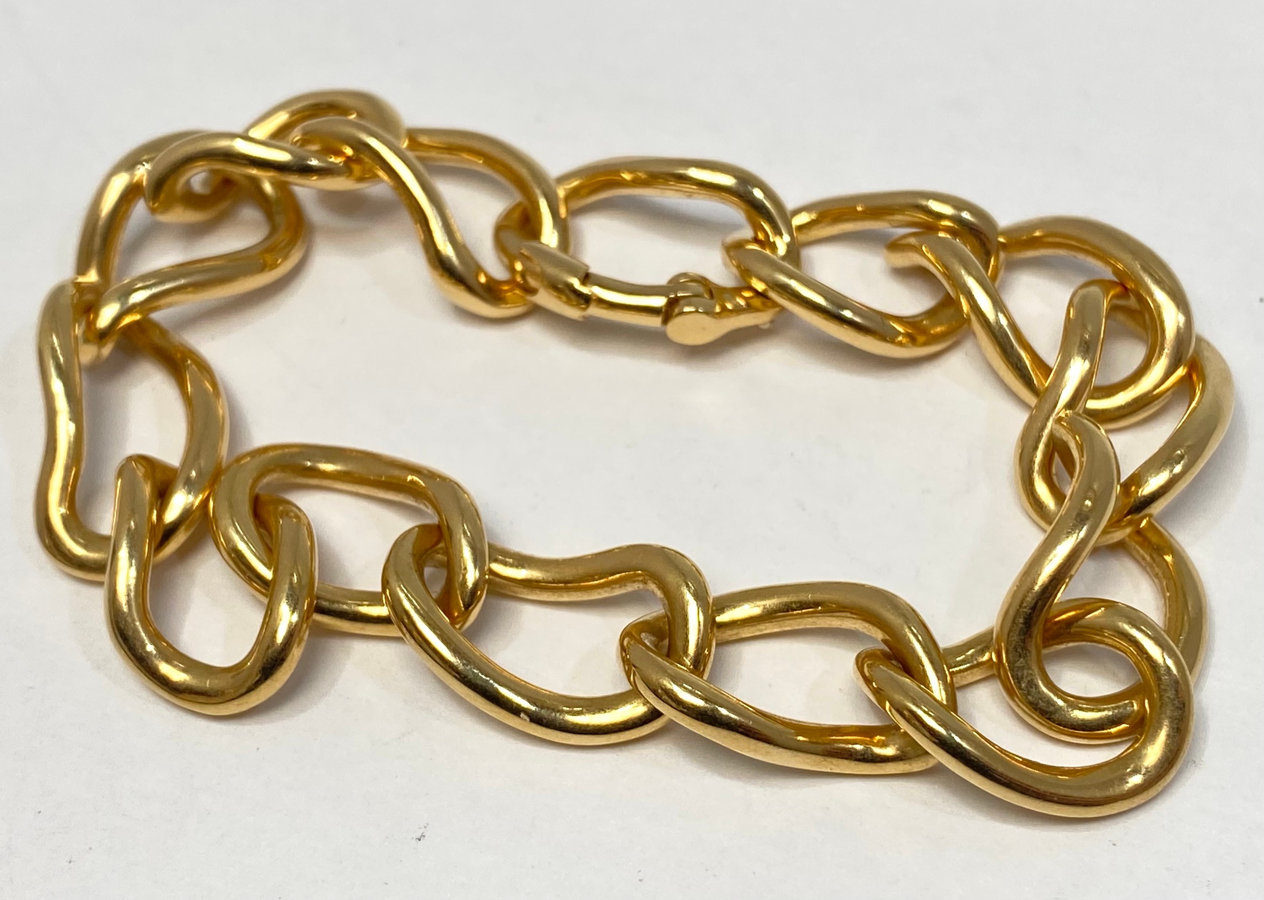 An 18ct gold bracelet of interlocked curved links, with hidden clasp fastening, weighing 38.4 grams.