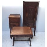 A stained and carved oak standing corner cupboard, with panelled doors enclosing shelves and