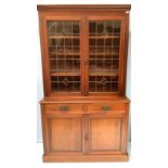 An Edwardian stained bookcase, above leaded glazed doors enclosing adjustable shelves, a pair of