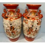 A pair of Japanese satsuma vases decorated with scenes of ladies amidst flowers with mountains and