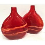 A pair of large red glass vases of flattened ovoid form, both with a pair of horizontal orange