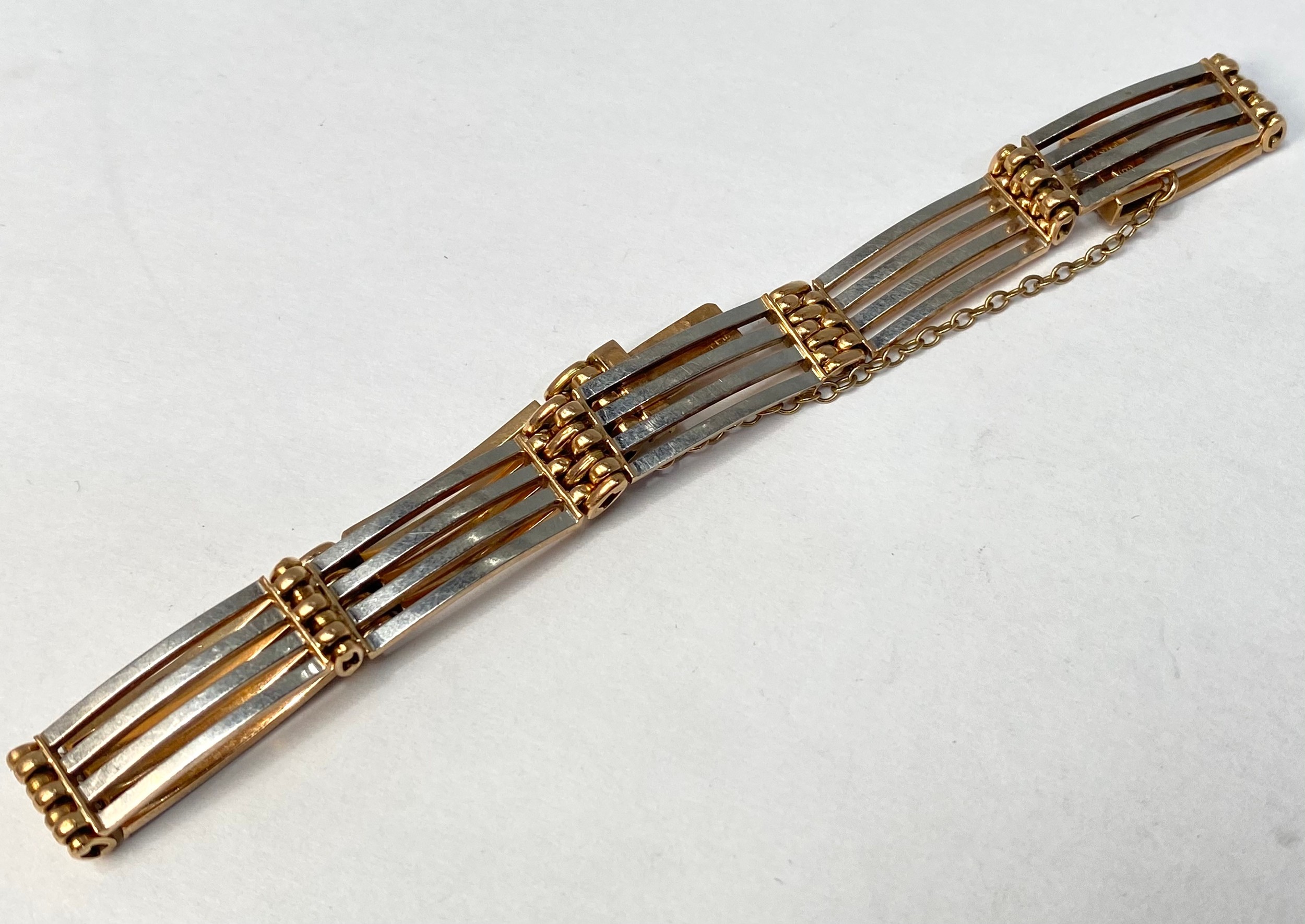 A 15ct gold and platinum gate-bracelet, weighing 15.7 grams.