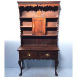 An 18th century stained oak dresser, of narrow proportions, the raised back with moulded cornice and