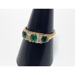 An 18ct gold ring set with three emerald coloured stones interspaced by two pairs of diamonds, 3.8g,