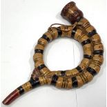 A 19th century English Prattware style coiled 'serpent' pottery pipe, finished with beige, black,