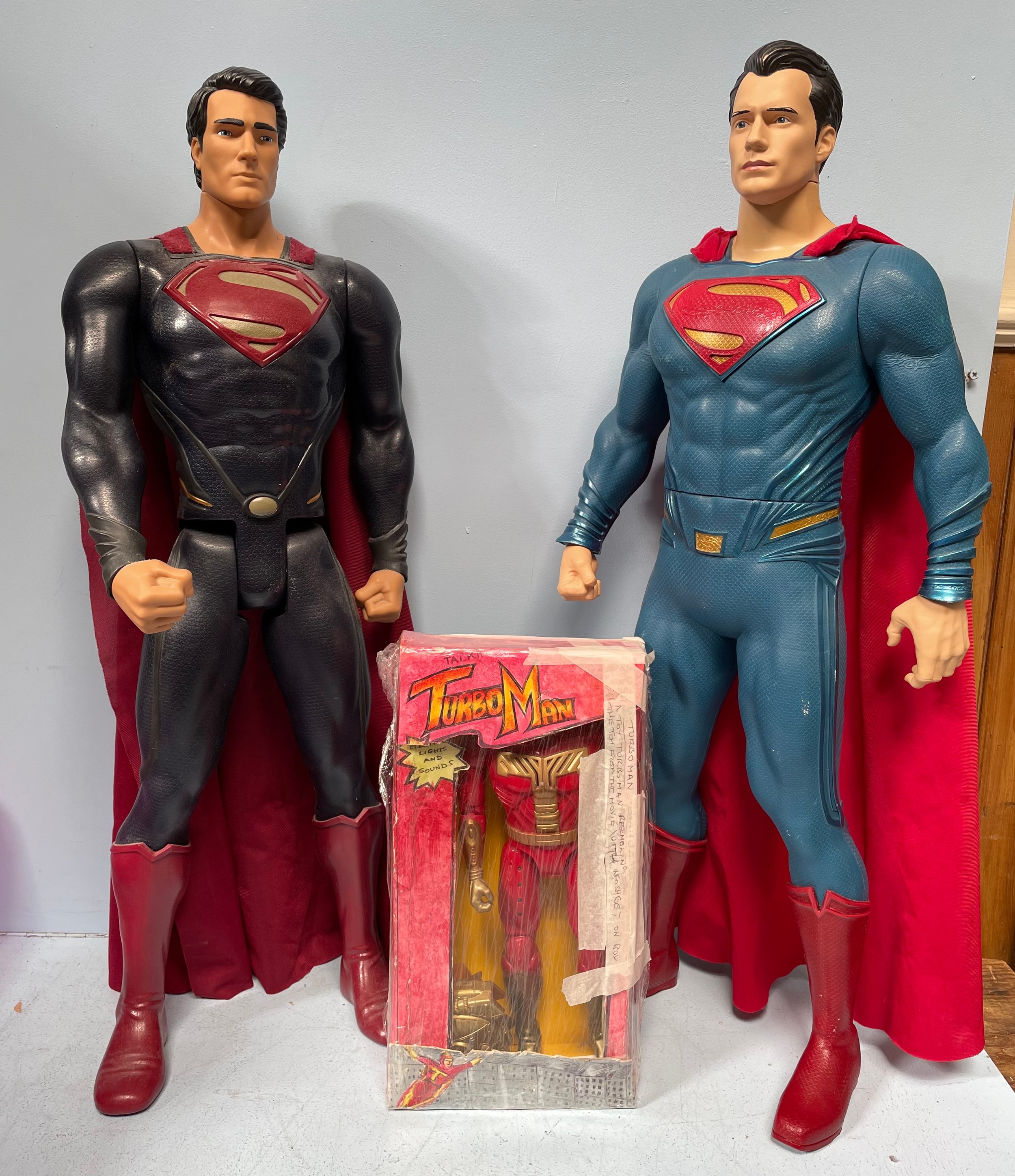 Two large Superman figures by Jakks, 80cm high, together with a Turboman doll from the film Jingle