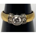 An 18ct yellow gold diamond ring, set with a round brilliant cut diamond to the centre in a white