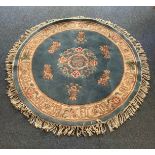 A machine made circular tufted wool rug with central medallion to blue ground, 150cm diameter,