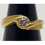 An 18ct yellow gold solitaire diamond ring, set with a round brilliant cut diamond in a wave and