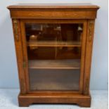 A Victorian walnut pier cabinet, the inlaid frieze above a single glazed door enclosing shelves,
