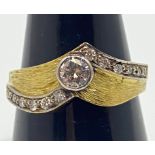 An 18ct gold diamond ring, set with a round brilliant cut diamond to the centre, and six smaller