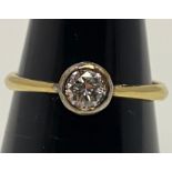 An 18ct yellow gold solitaire diamond ring, set with a round brilliant cut diamond in a rub-over