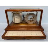 An aneroid barograph, in glazed oak rectangular display case with silvered 'change' dial, by