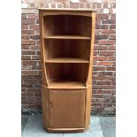 An Ercol blonde elm corner cabinet, with two shelves above a single cupboard, 180 x 75cm
