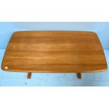 An Ercol blonde elm coffee table, of rectangular form and raised on trestle supports with stretcher,