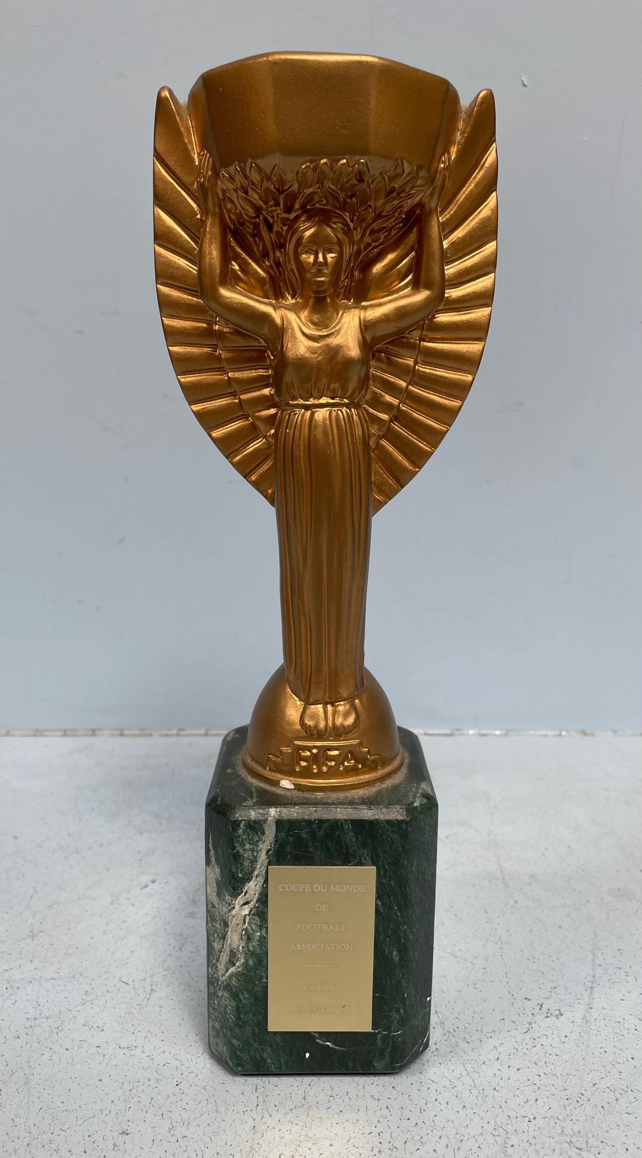 A replica Coupe Du Monde De Football Association trophy by Jules Rimet, 33cm high, together with a