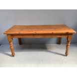 A pine dining table of rectangular form and plain frieze, raised on turned supports, 183cm long,