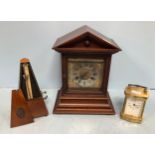 An oak cased mantel clock by Junghans, with Roman numerals denoting hours, together with a brass