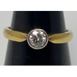 An 18ct yellow gold diamond ring, set with a round brilliant cut diamond in a rub-over bezel