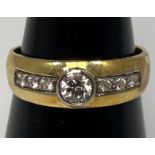 An 18ct yellow gold diamond ring, set with a round brilliant cut diamond to the centre, in a rub-