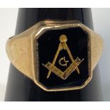 A yellow metal (marked 9ct) signet ring, with black onyx top with masonic symbol in gold, weighs 5.1