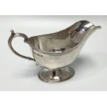 A silver cream jug by Mappin & Webb, of plain design and raised on spreading, oval foot, 13.5cm