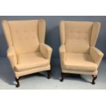 Two upholstered wingback armchairs. with sprung back and base, loose cushion with cream trellis