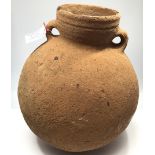 A large Middle Eastern terracotta amphora style round bottomed water vessel with twin handles,