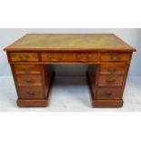 A mahogany pedestal desk, the top with green leather scribe, above a long central drawer and two