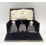 A collection of assorted silver topped toilette jars including a cased three-piece cruet set by