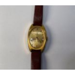 A lady's yellow metal Tissot wristwatch with oval case, gold coloured dial with batons denoting