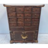 A Chinese stained and brass bound hardwood apothecary cabinet, formed of 16 small drawers with