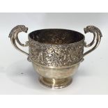 A silver twin-handled bowl, the top half decorated in relief with a continuous hunting scene,