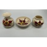 Six Moorcroft pottery items including two various small vases and a dish decorated with deep red and