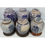 Six various Chinese blue & white porcelain 'shuangxi' ginger jars and covers, on wooden stands,