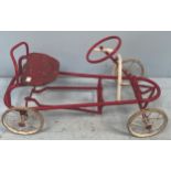 A 1950s red and white painted pedal car with wooden seat