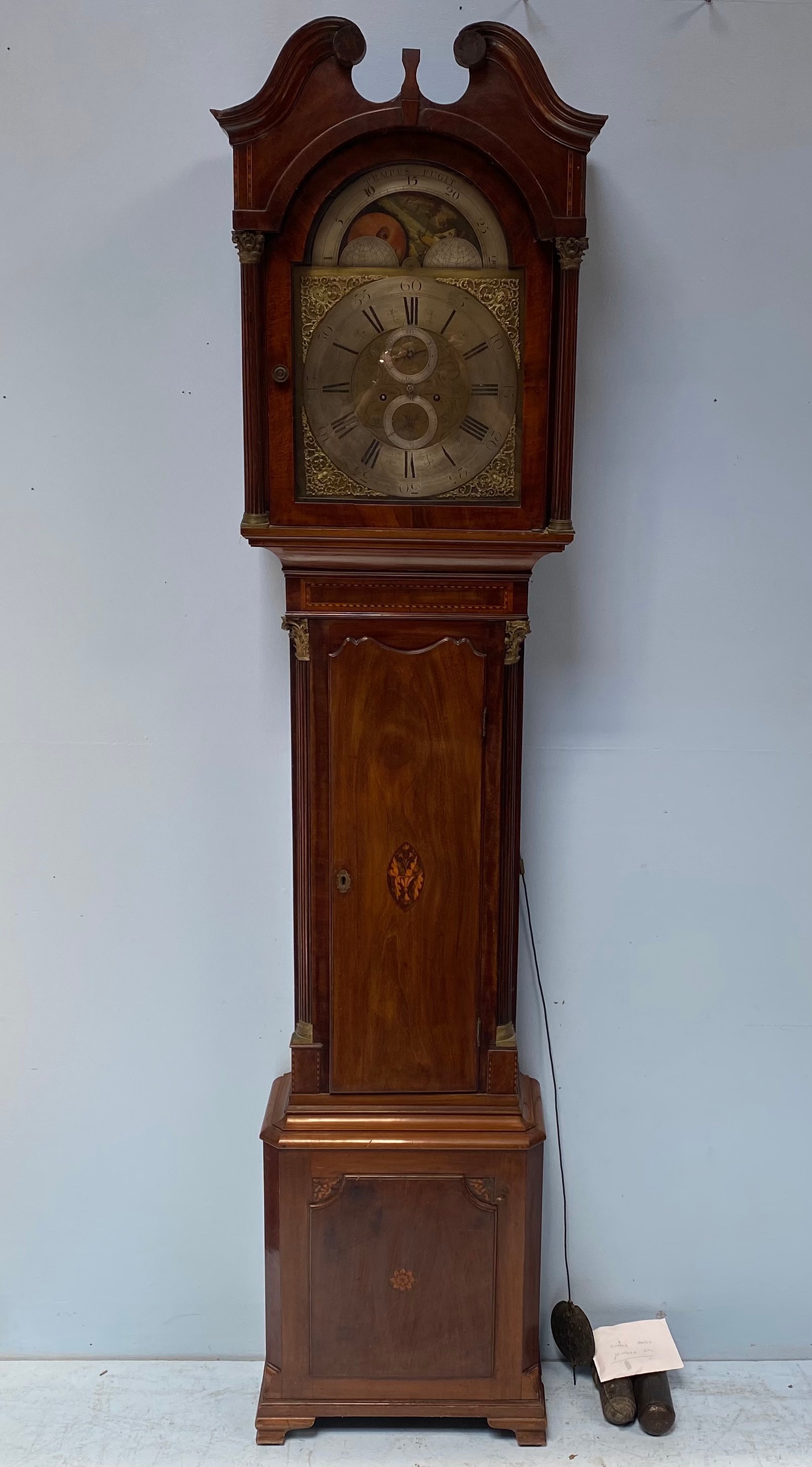 An 18th century longcase clock with swan neck pediment and arched glazed door enclosing moon phase