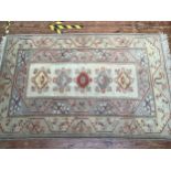 A hand-knotted Caucasian wool rug, with five central coloured guls, to a cream ground and