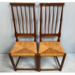 A pair of Arts and Crafts style rush seated chairs with tall spindle backs, turned sides and back