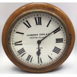 A mahogany cased circular wall clock with white enamel dial and black roman numerals, marked to