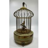 A 20th century singing bird automaton with gilt birdcage housing a yellow bird on a perch with