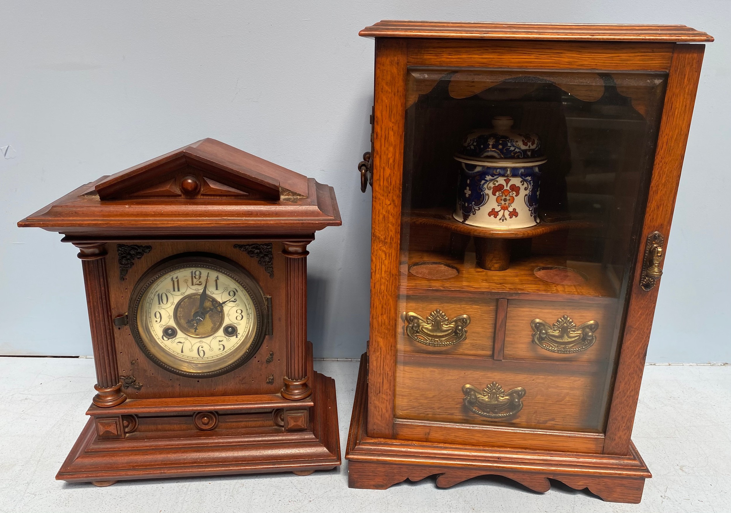 An Edwardian stained oak smoker's cabinet, with single glazed door enclosing drawers and ceramic