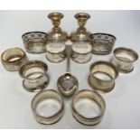 A small collection of assorted silver items comprising a pair of loaded squat candlesticks by J.