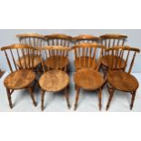 A set of eight beech spindle back dining chairs, raised on turned supports