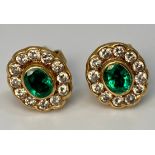 A pair of 18ct gold earrings set with central oval green stone measuring 4x3mm surrounded by 12
