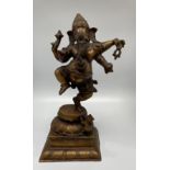 A large bronzed figure of Lord Ganesh, God of good luck and auspiciousness, modelled on one leg with