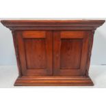 A stained mahogany miniature hanging cupboard, possibly an apprentice piece, stepped cornice above a