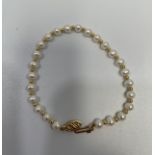 A freshwater pearl and 9ct gold ball bracelet, on 9ct yellow gold fastening.
