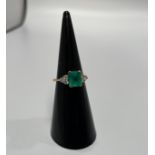 An 18ct yellow gold emerald & diamond dress ring, set with a Columbian emerald to the centre and